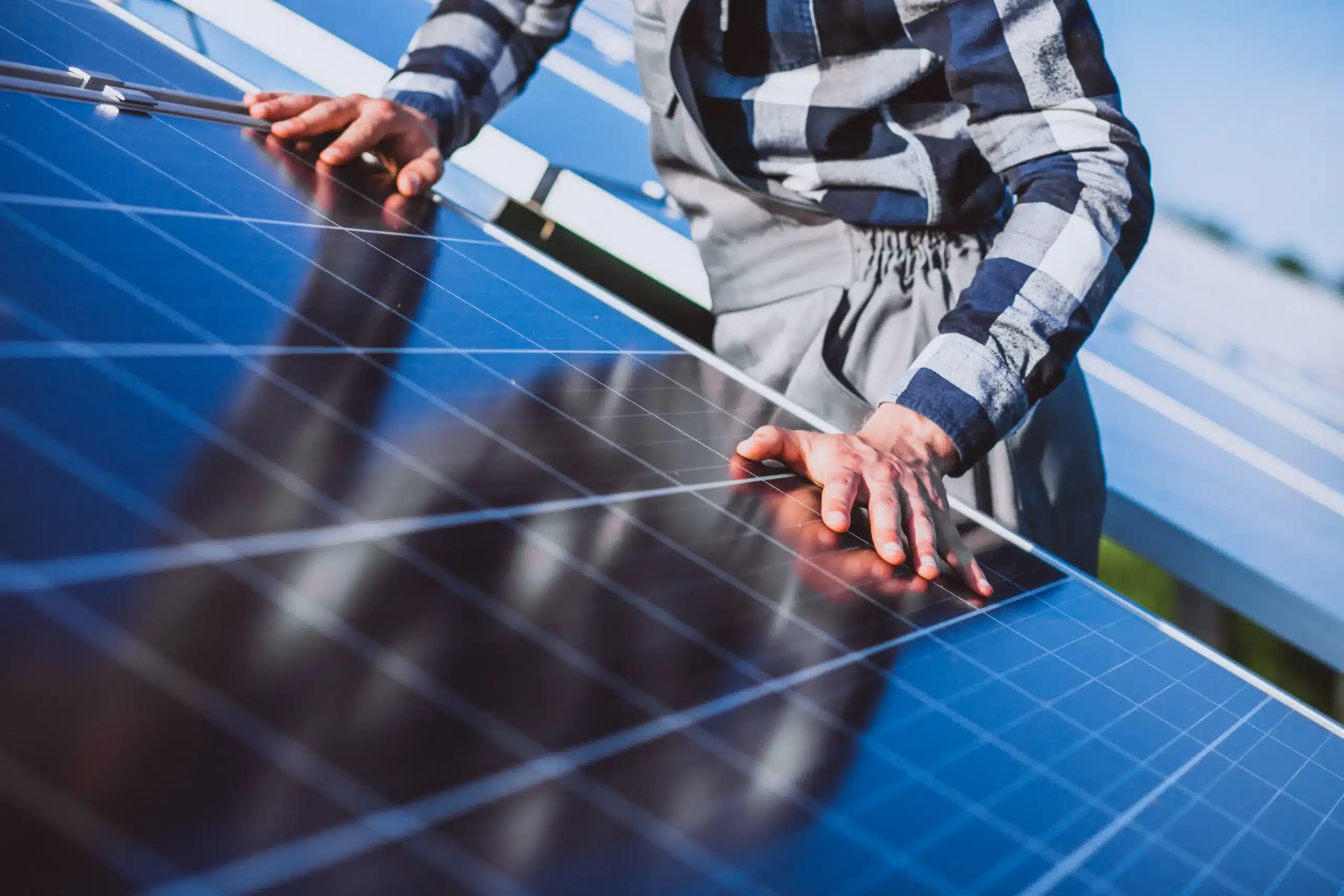 man worker in the firld by the solar panels scaled